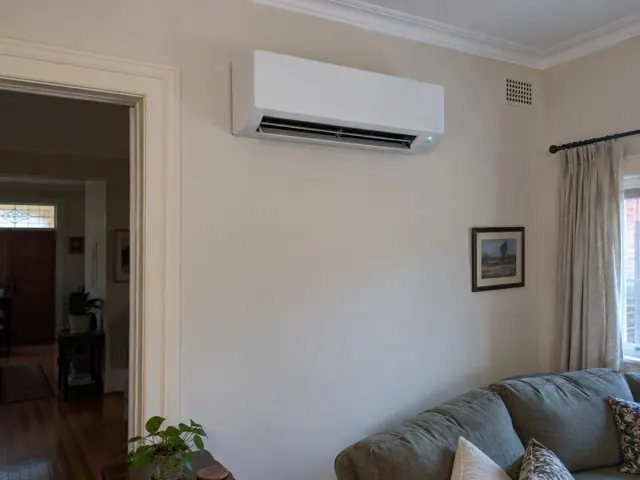 White split system on a cream wall above a living room sofa in a home in Prospect