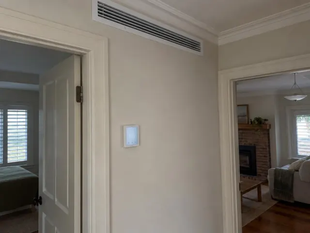 Ceiling return-air grille and wall zone controller in a hallway with adjoining rooms in Adelaide